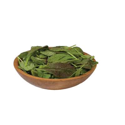 Wooden bowl filled with green leaves on a white background