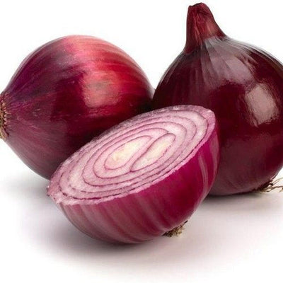 Red onions with one sliced open on a white background